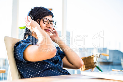 Smiling asian businessman listening to music