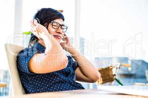 Smiling asian businessman listening to music