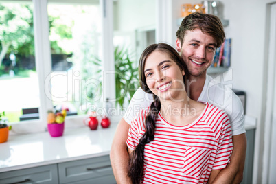 Happy couple standing in kitchen