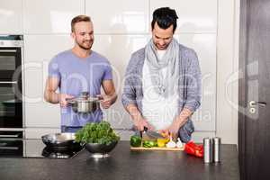 smiling gay couple preparing food