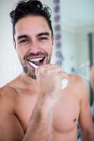 Handsome man brushing his teeth