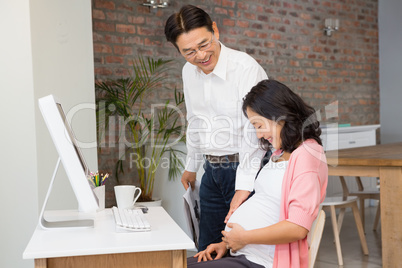 Happy couple touching pregnant belly
