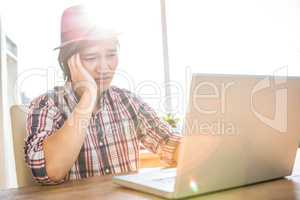 Worried hipster businessman using laptop