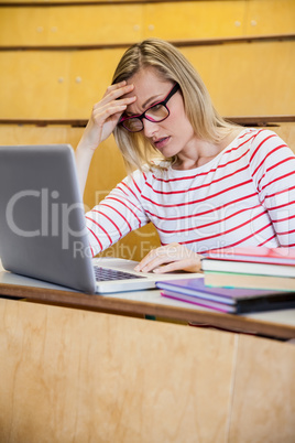 Busy female student working on laptop