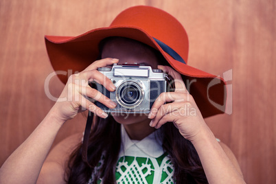Woman with hat taking photograph with camera