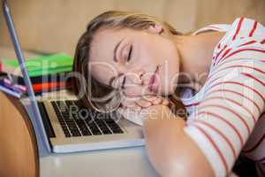 Female student sleeping in class on her laptop