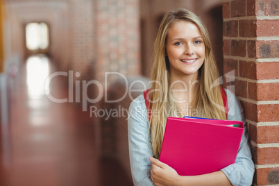 Smiling student with binder posing