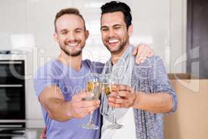 Smiling gay couple toasting with champagne