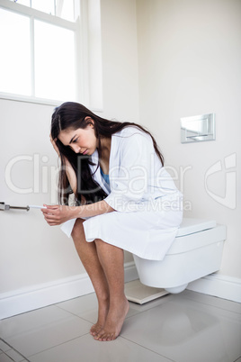 Woman in bathrobe looking at her pregnant test
