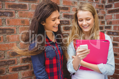 Smiling students using smartphone