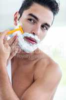 Handsome man shaving his beard