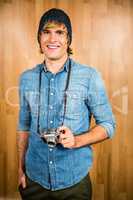 Smiling hipster man holding digital camera