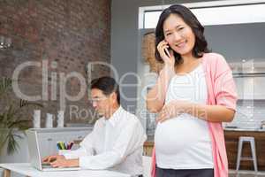 Smiling pregnant woman on a phone call