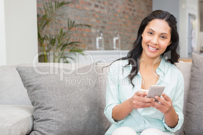 Smiling brunette using smartphone