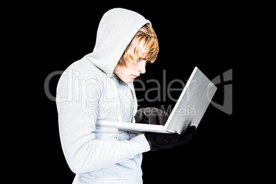 Focused man with hoodie typing on laptop
