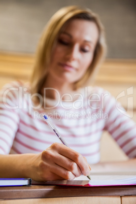 Female student taking notes in a class