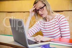 Busy female student working on laptop