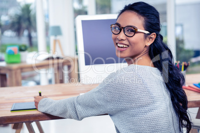 Smiling Asian woman using digital board looking back at the came