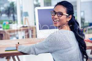 Smiling Asian woman using digital board looking back at the came