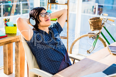 Smiling asian businessman listening to music