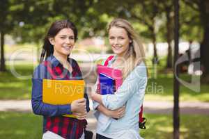 Smiling students holding binder