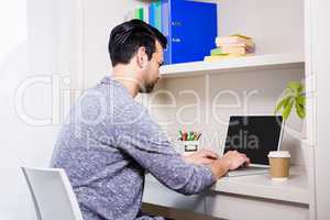 Focused man typing on laptop