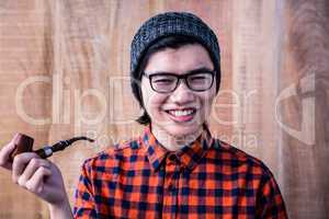Smiling hipster holding pipe