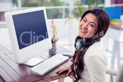 Smiling Asian woman with headphones around neck
