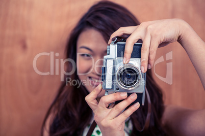 Smiling Asian woman taking photograph with camera
