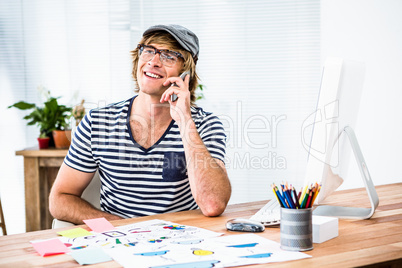 Smiling hipster businessman talking on the phone