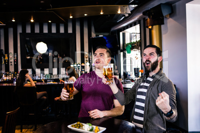 Friends having a pint and watching tv