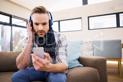 Handsome man listening music on the couch