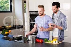 smiling gay couple preparing food