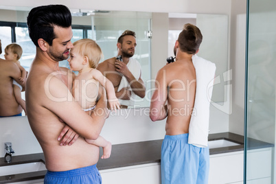 Smiling gay couple with child