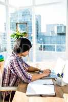 Serious hipster businessman using laptop