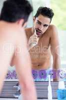 Handsome man brushing his teeth