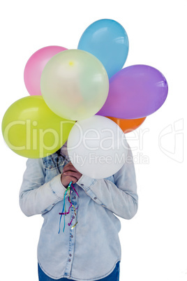 Asian woman hiding her face behind colorful balloons