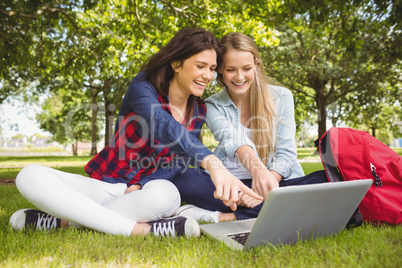 Smiling students using laptop