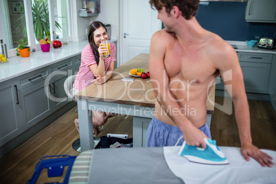 Handsome man ironing in the kitchen