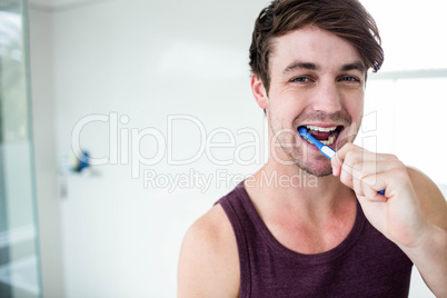 Handsome man cleaning his teeth