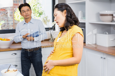 Suffering pregnant woman touching her belly