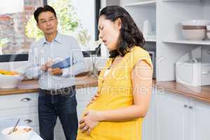 Suffering pregnant woman touching her belly