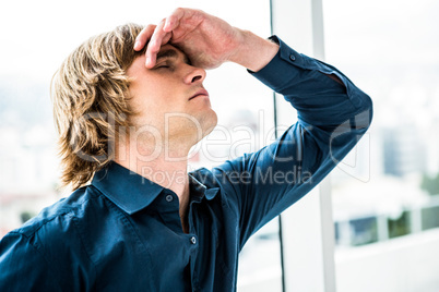 Troubled hipster businessman holding his head