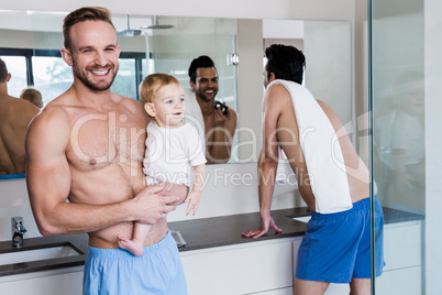 Smiling gay couple with child