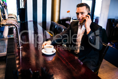 Businessman on the phone having a coffee