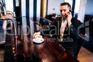 Businessman on the phone having a coffee