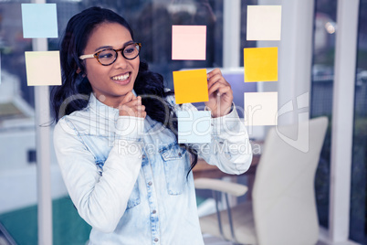 Asian woman looking at sticky notes