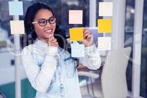 Asian woman looking at sticky notes