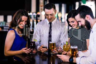Group of friends texting and having a drink