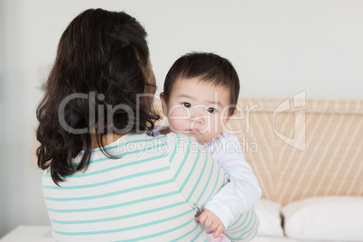 Lovely mother carrying baby daughter